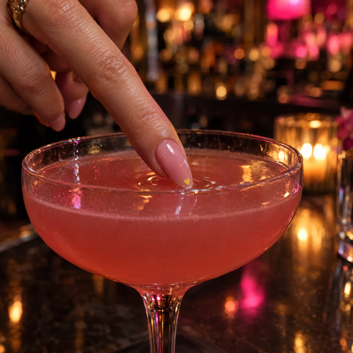 Nail with TipShield sticker dipped into a cocktail